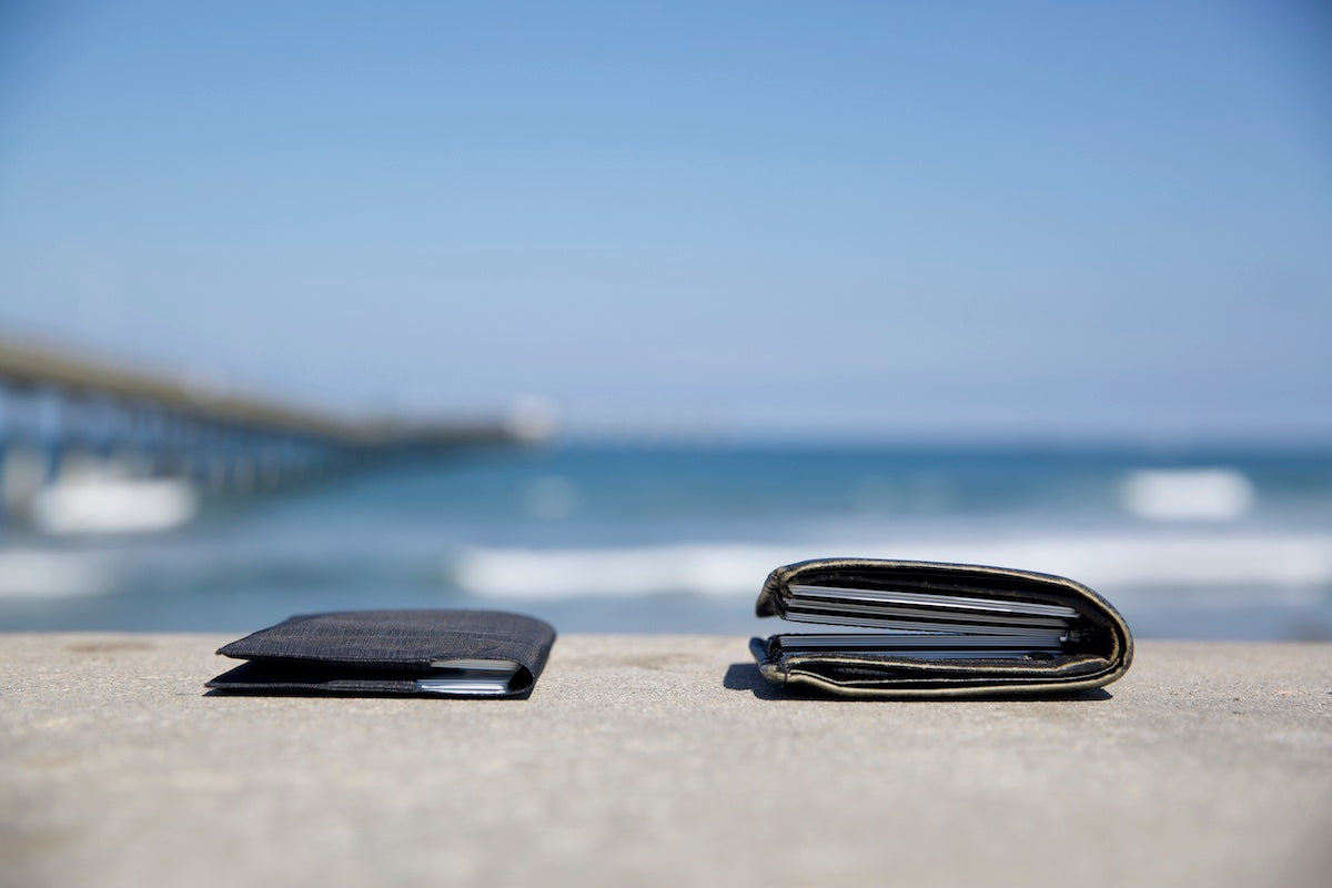 Photo showing the size of two different wallets. The left wallet is a thin wallet by Allett, and the right wallet is a much bulkier wallet by a designer brand.