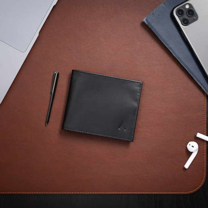 Black leather ID wallet made from ultra slim Nappa leather against a brown table. Allett id wallet leather onyx-black