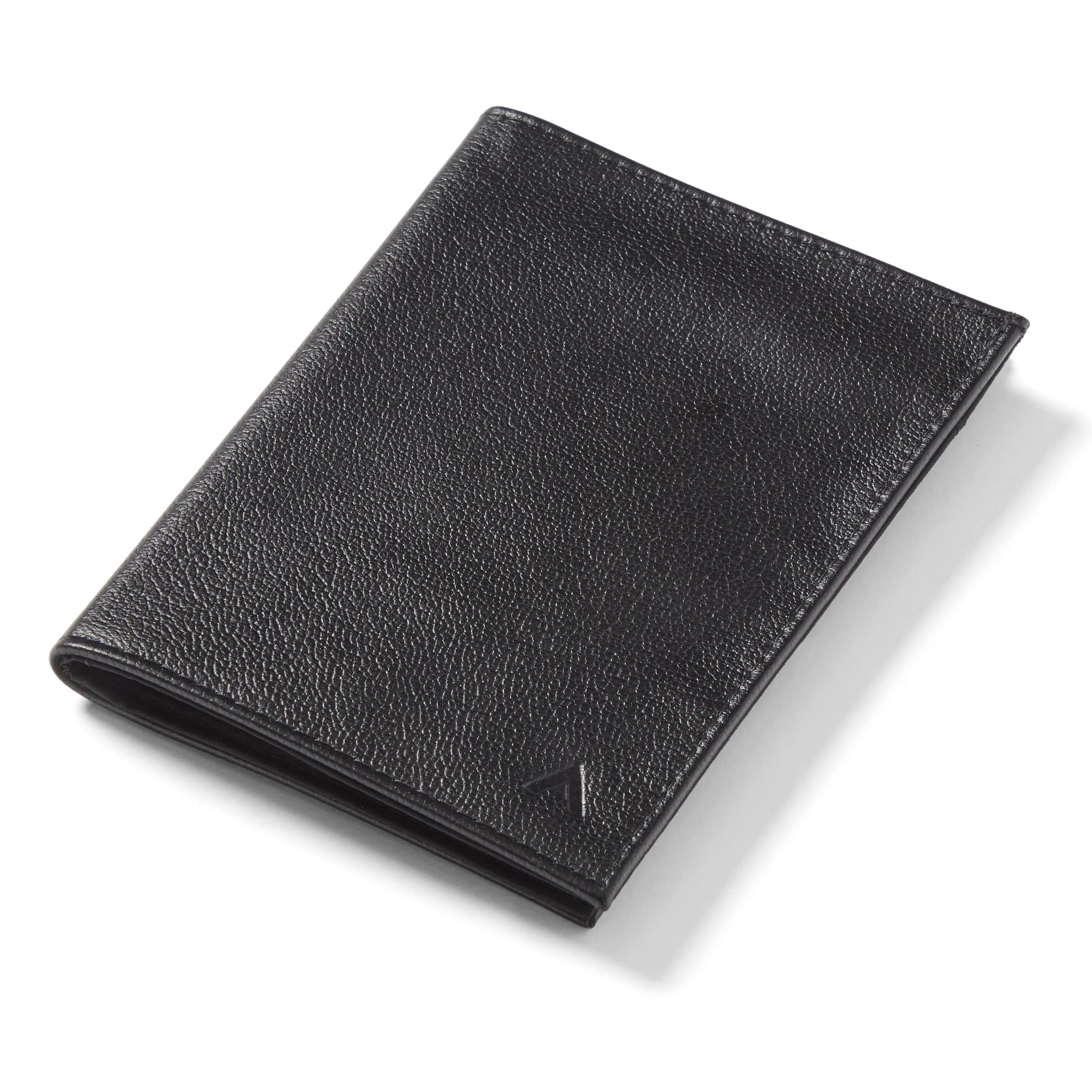 Black leather wallet designed for passports laying flat against a table - black