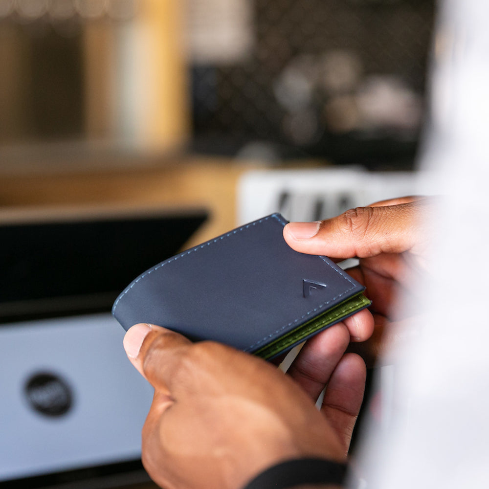 Hands lightly bending the Allett leather sports wallet to show how tactile it is. Allett Leather Sport Wallet-  midnight-blue