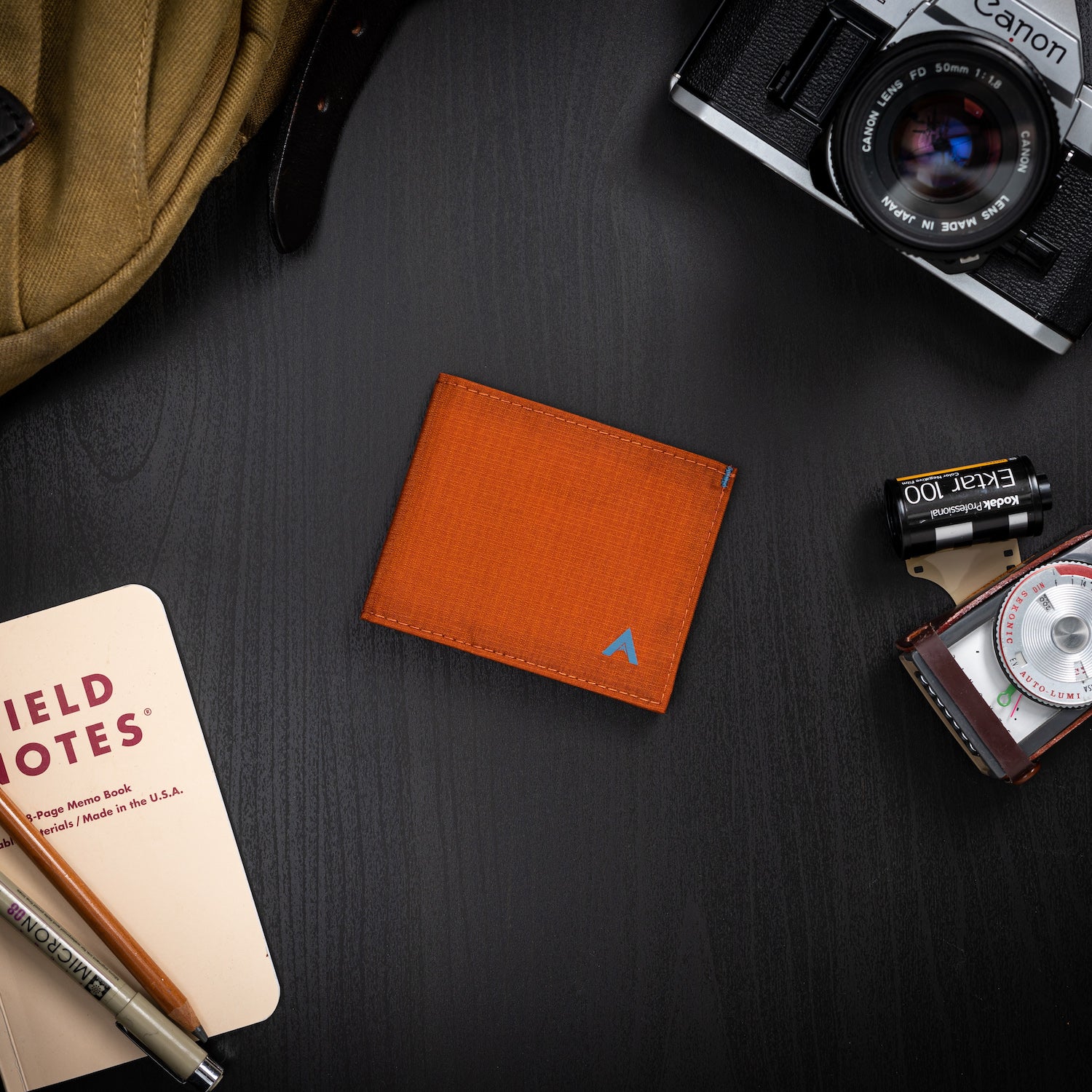 Allett's potters clay RFID sports wallet, accompanied by a micropen and other essential everyday items on a black table - Allett Sport Wallet RFID Nylon Front Pocket Wallet potters-clay