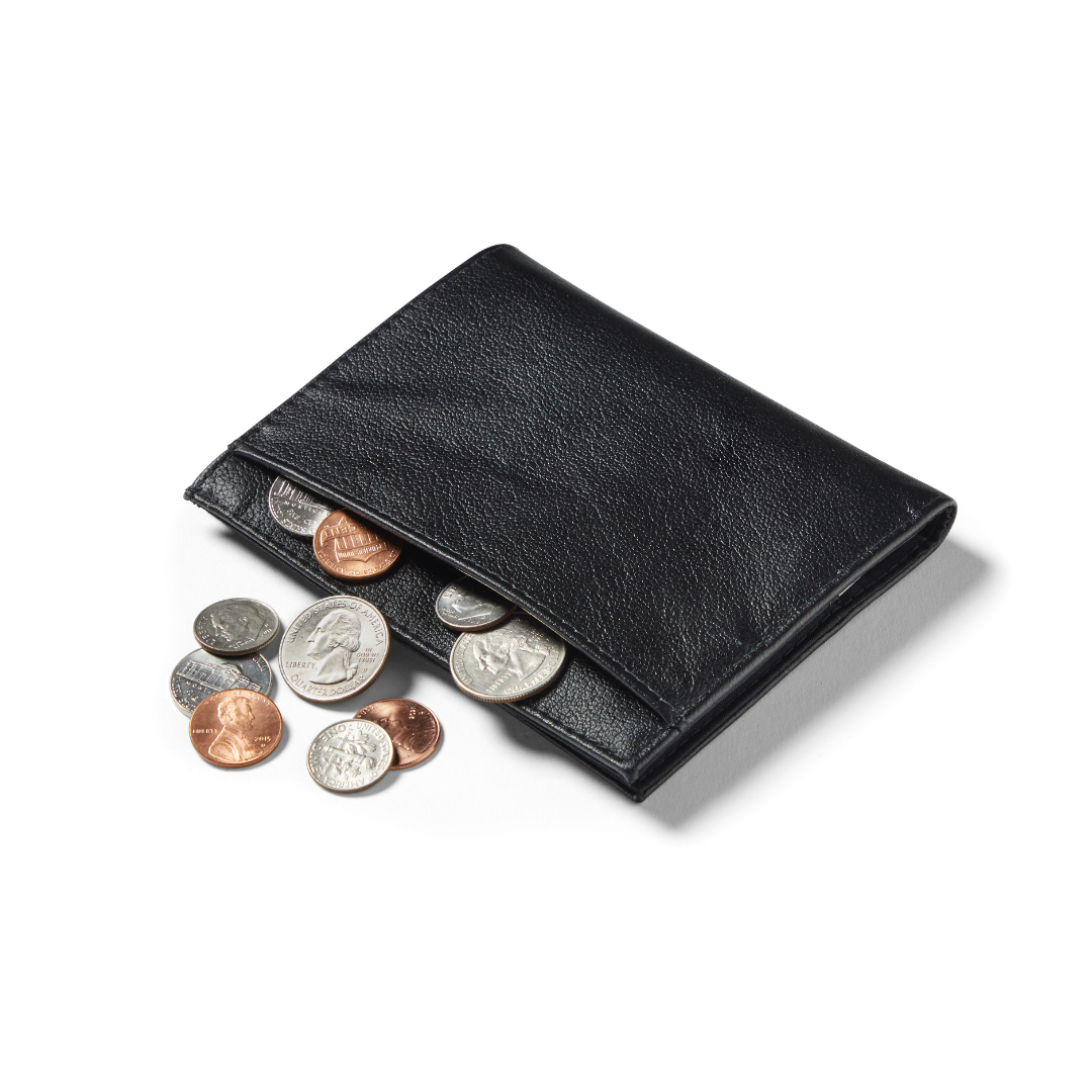 Coins cascading from the exterior pocket of the slim onyx black Allett coin wallet. allett leather coin wallet onyx-black